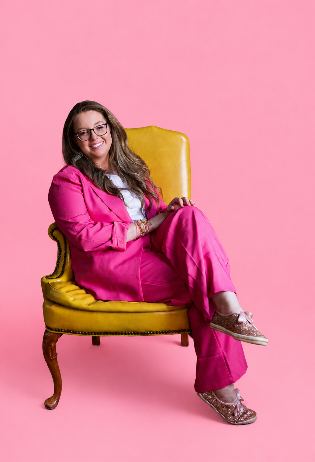 Katie seated in a chartreuse chair holding a vintage phone